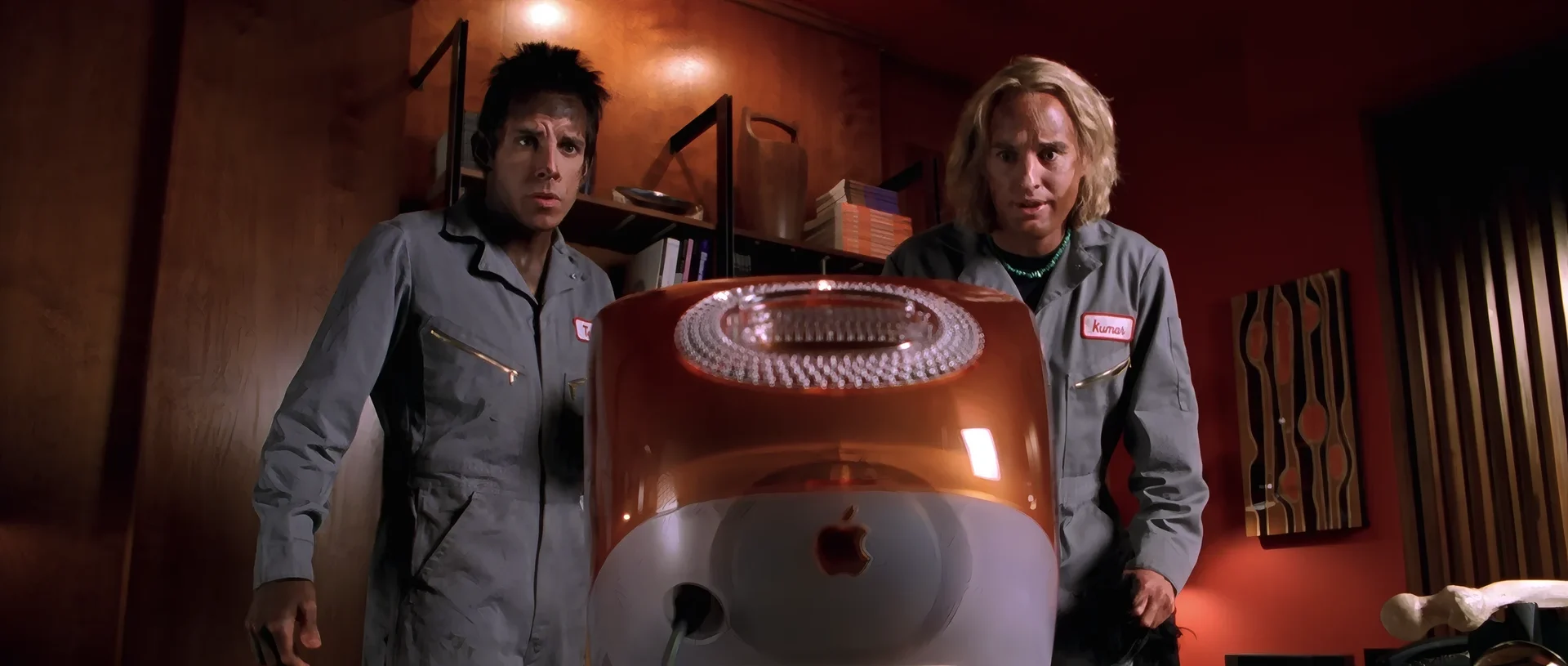 Derek and Hansel staring at the back of an orange iMac, as if the files are inside it.